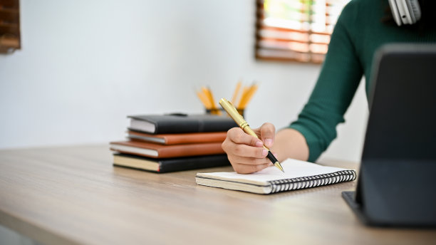 女性在她的螺旋笔记本上写笔记。特写和裁剪镜头图片下载