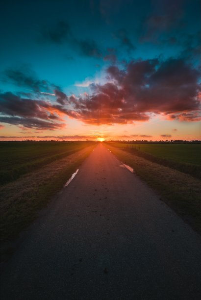 荷兰泽兰拍摄的日落时被草地包围的道路垂直照片图片下载