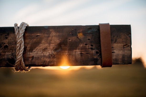 特写镜头的木材与皮革和绳索包裹它与模糊的背景图片下载