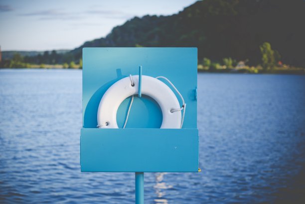 近景拍摄的一个救生圈在一个蓝色的看台附近的海与模糊的背景图片下载