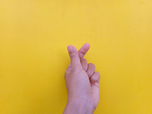 手指的心。女人的手与法式美甲手势在黄色背景。系列的一部分图片下载