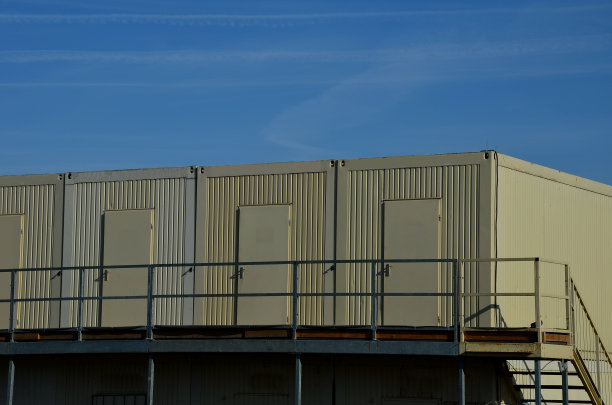 堆叠容器单元中的模块化外壳。每个模块都有不同的功能。它包括一个楼梯厕所，一个办公室厨房和一个壁挂式空调。将电源线连接到插座图片下载