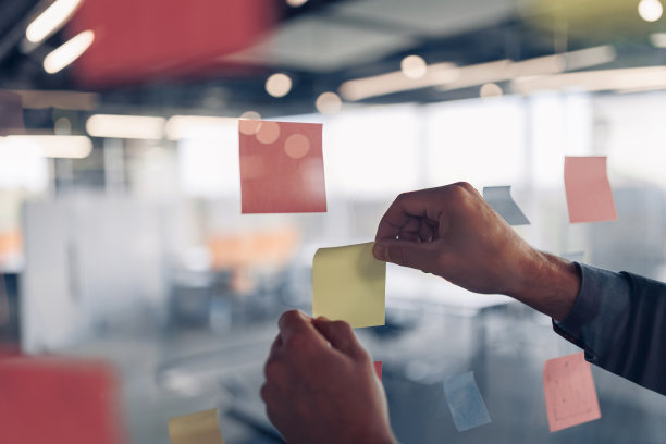 女商人的手是在办公室的激励板上贴便利贴图片下载