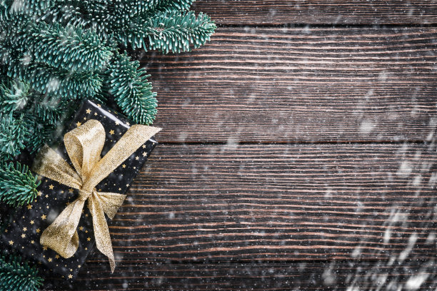 圣诞冷杉树枝，圣诞球，礼盒，木制雪花和星星在老布朗木制背景为您的圣诞问候。带有复制空间的俯视图。圣诞贺卡。图片下载