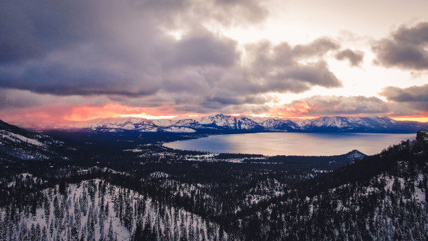 阿里尔拍摄的南太浩湖附近的雪林与多云的天空图片下载