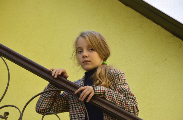美丽的女孩把手放在楼梯的铁栏杆上思考着图片下载