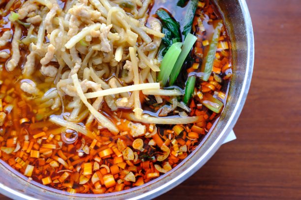 头顶上一张木桌上的金属碗里盛着蔬菜片的汤图片下载