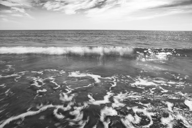 灰暗多云的天空下疯狂的海浪的灰度照片图片下载