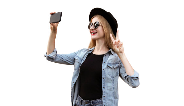 照片中快乐微笑的年轻女子正在用智能手机自拍，戴着白色背景的黑色圆帽图片下载