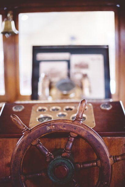 垂直闭合镜头的船方向盘与模糊的背景图片下载