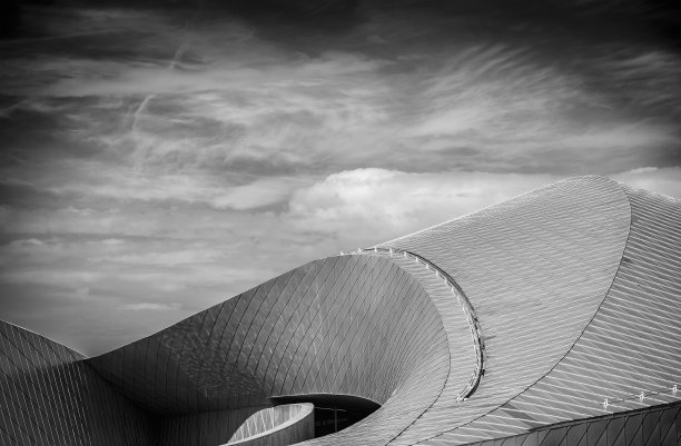 在多云的天空下，一个圆顶状建筑的灰度镜头图片下载