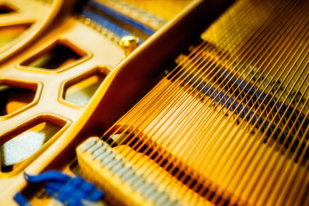 一架金色琴弦的钢琴内部的美丽镜头——音乐在心中的概念图片下载