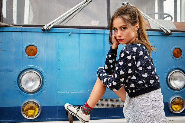一辆旧公共汽车前年轻女子的肖像图片下载