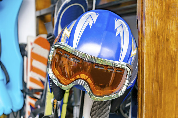 头盔，滑雪面罩，滑雪板在定制墙上安装在仓库。极限冬季运动装备图片下载