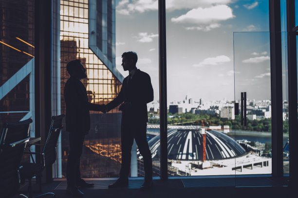 两个合伙人在现代化的会议室里互相问候图片下载