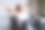 一名穿着白衬衫的年轻女子拿着笔记本电脑坐在沙发上，在工作中坐了很长时间后，她把手臂举过头顶伸展开来。图片下载