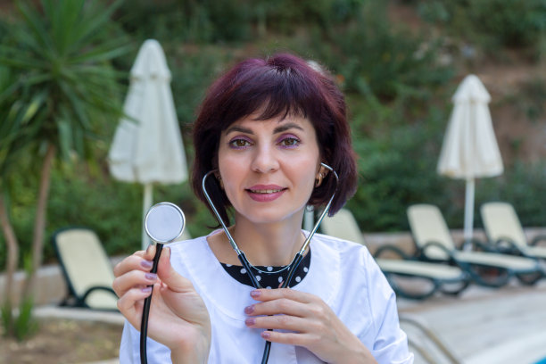 女医生手里拿着听诊器在大自然中图片下载