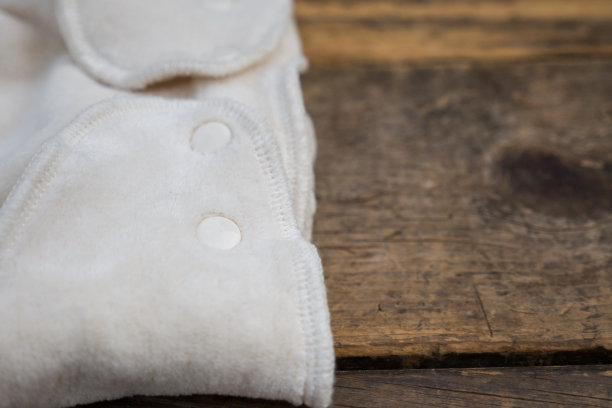 木质表面上有机白色婴儿尿布的特写镜头图片下载