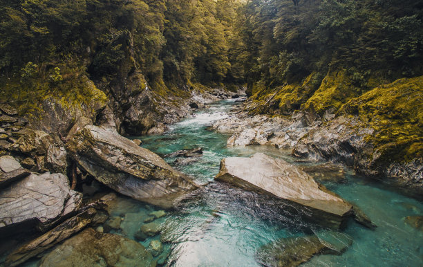 悬崖上树木环绕的小溪上岩层的美丽照片图片下载