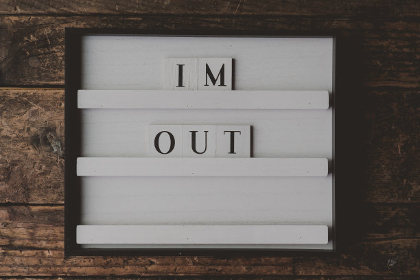 白色的牌子，棕色的木质背景上写着“我出去了”图片下载