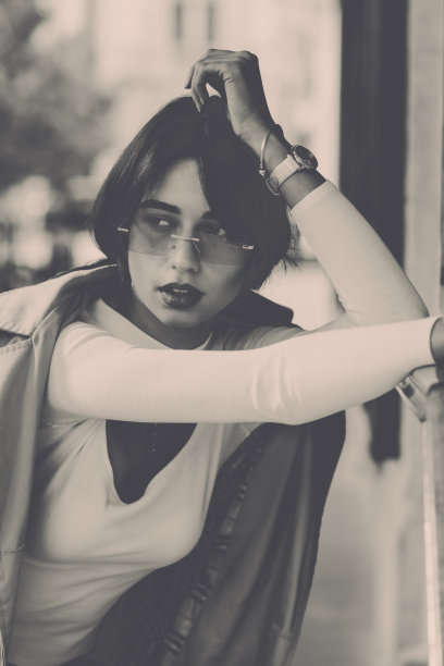 美丽的黑发女孩，戴着太阳镜，穿着白色衬衫和米色外套。时髦时髦的时尚观图片下载