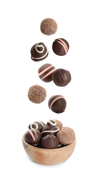美味的甜巧克力松露落入白底木碗图片下载