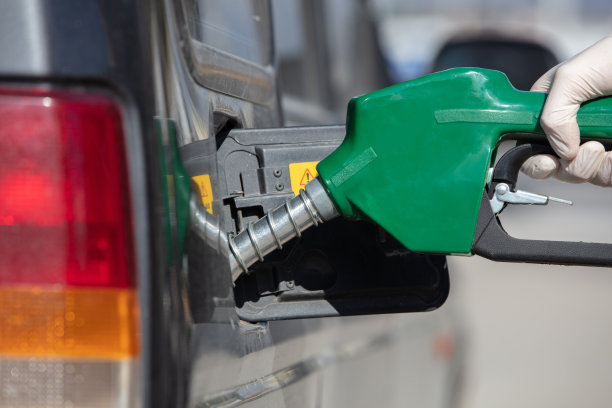 一个人往车里倒汽油的手的特写镜头图片下载