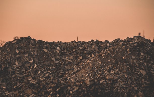 深色拍摄的工业垃圾场在岩石与粉红色的背景图片下载