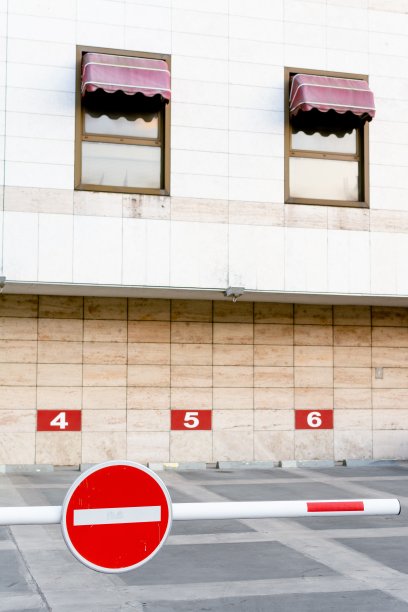 垂直拍摄的现代白色建筑，有两个窗户和前面的街道标志图片下载