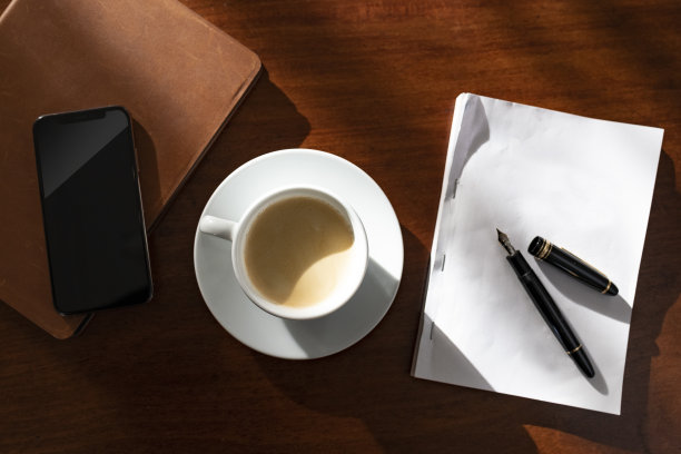高角镜头的桌子上，一个作家拿着一支纸笔和一杯咖啡图片下载