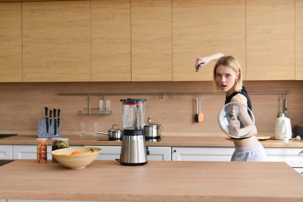 女人在厨房里玩得像个拿着剑和盾的战士图片下载