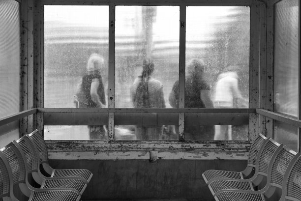 空荡荡的房间，椅子和站在窗后的人都是黑白的图片下载