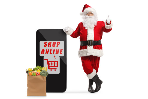 圣诞老人靠在智能手机上，一边用文字在网上购物，一边竖起大拇指图片下载