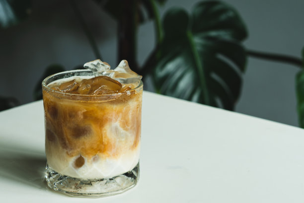 冰拿铁咖啡在透明的玻璃上白色的桌子背景，自制咖啡，夏日的饮品概念图片下载