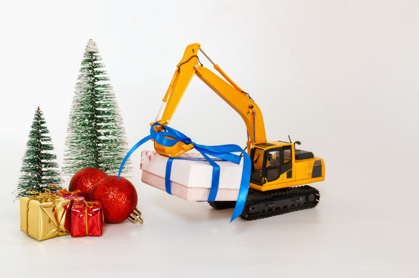挖掘机模型与升降机礼盒，节日庆祝概念新年在白色背景图片下载