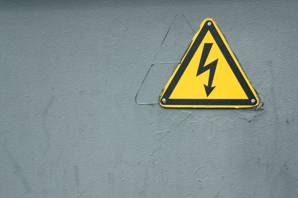 灰色墙壁上的电力警告特写镜头图片下载