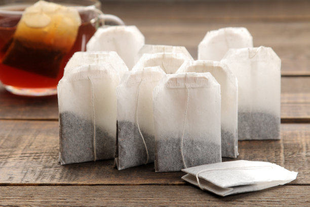 茶包特写在棕色木制背景泡茶。图片下载