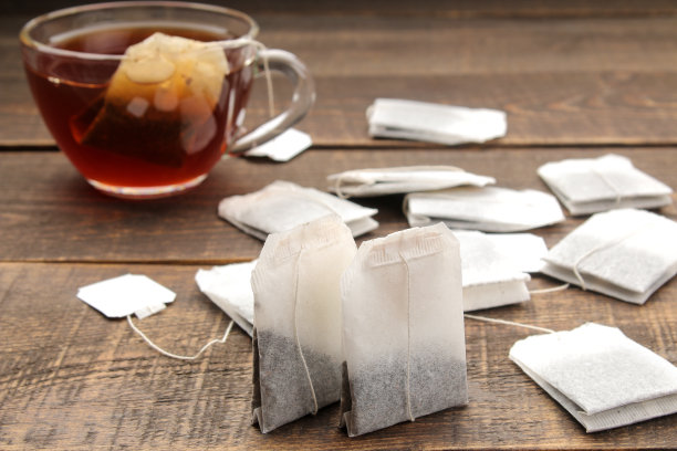 茶包特写在棕色木制背景泡茶。图片下载