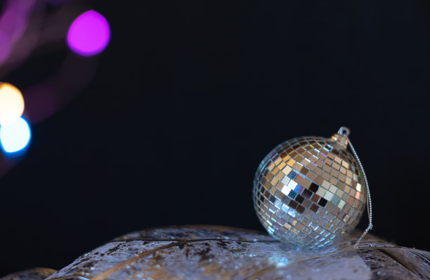 银色迪斯科镜球圣诞小玩意与选择性聚焦对黑色背景。圣诞节或冬季节日的庆祝概念。新年贺卡与复制空间的文字图片下载