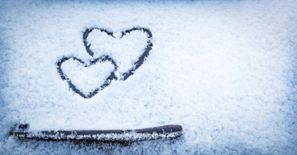 一辆汽车雨刷上方的玻璃上画着两只心形的手。图片下载