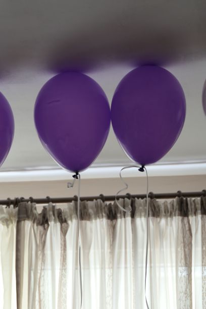 派对上紫色氦气球碰到天花板的垂直镜头图片下载