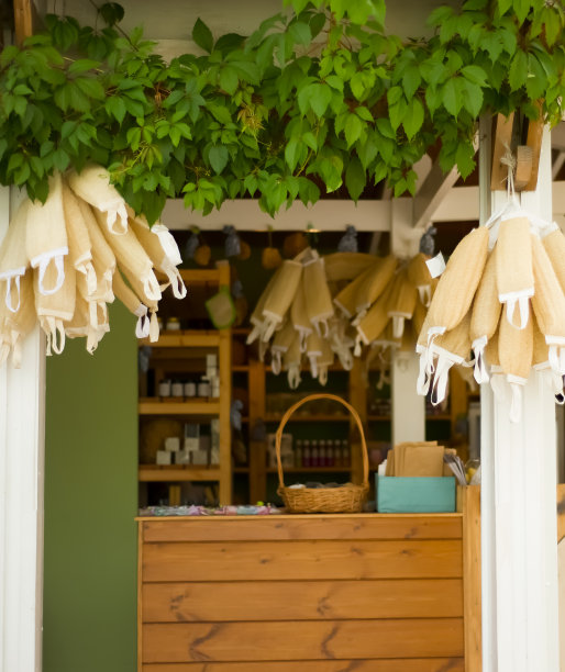 在街上购买手工制作的天然化妆品。入口处装饰着枝状植物和天然毛巾。身体按摩用品。面霜和油自然环保。选择化妆品。图片下载