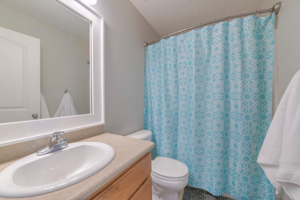 洗手池配有镜子、抽水马桶和闭合的蓝色窗帘图片下载