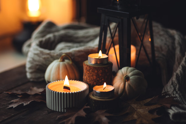 舒适的秋天组成芳香蜡烛，南瓜，羊毛毛衣，树叶，肉桂。在一个灰蒙蒙的秋日早晨做香薰，家里的气氛舒适而放松。木制背景特写。图片下载