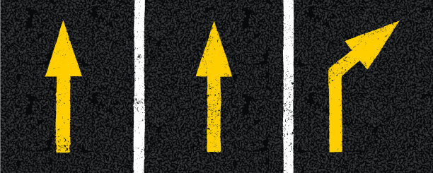 柏油路面俯视图上的黄色方向箭头标志图片下载