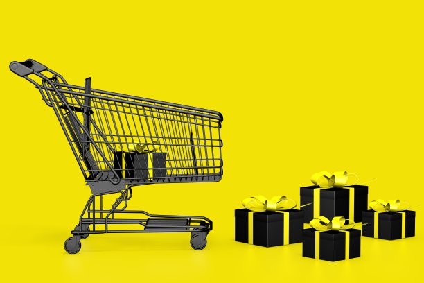 黑色礼品盒和购物车在黄色背景，复制空间。黑色星期五的概念图片下载