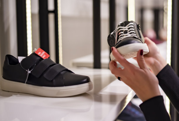 年轻女子在商店选择运动鞋鞋图片下载