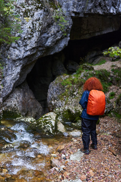 背着背包的女游客在有河的山洞里图片下载