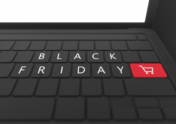 具有明亮发光屏幕的笔记本电脑。黑色星期五和键盘上的购物车图标。黑色背景。副本的空间。在线购物。网络星期一。图片下载