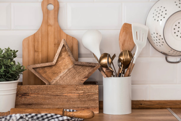 盘子和餐具放在厨房的木质台面上，准备做饭。北欧风格的白色现代厨房，厨房细节。图片下载